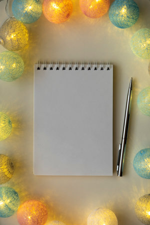 Opened planner with garland around it on white background.の写真素材