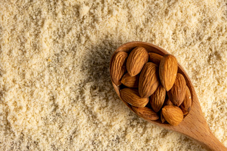Almond flour and almonds in wooden spoon. Gluten free food concept.の写真素材