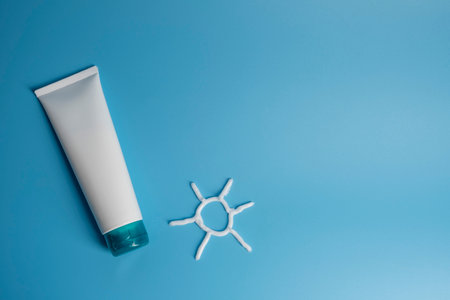 Plastic tube with sunscreen cream on blue background.の写真素材