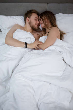 Portrait of a happy young couple having a nice time in bedの写真素材