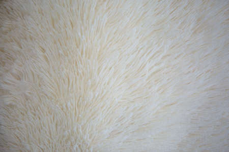 High quality white wooly texture of the blanket as the background. Fluffy faux textile fur close up