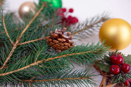 festive needles of a new year tree with bright toys, cones and berries on a white backgroundの写真素材