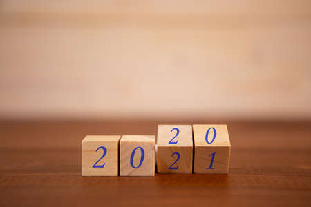 New year 2020 change to 2021 concept, hand change wooden cubes. close-up photo