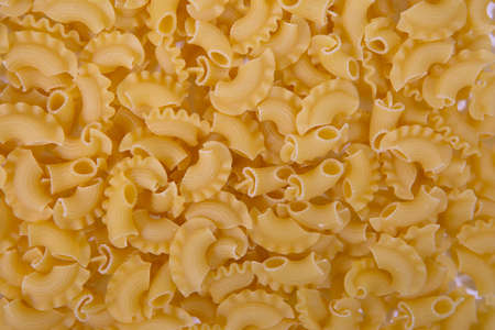 the background texture of Italian pasta. Golden-colored pasta