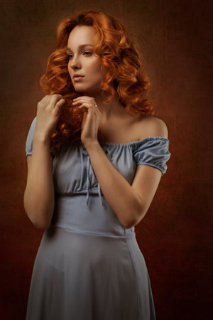 Portrait of a sexy red-haired woman with long hair on a red background. The perfect girl with blue eyes, beautiful clear skin, beautiful natural makeup, red hairの写真素材