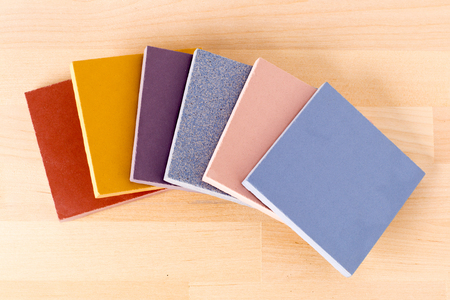 Samples of ceramic granite of different colors. On wood background, closeup.の写真素材