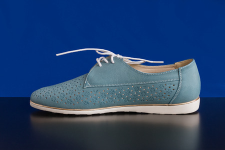 Women's summer sneakers with a lace on a blue backgroundの写真素材