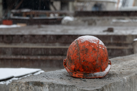 A construction orange helmet under snowの写真素材