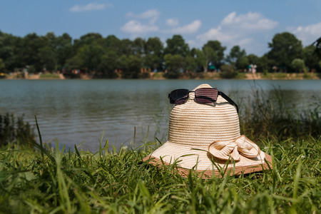 Straw hat on the bank of the lake in a sunny dayの写真素材