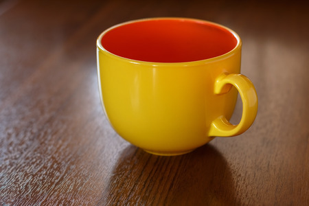 Yellow porcelain mug on a tableの写真素材