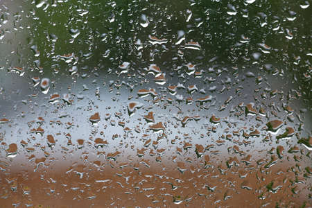 Raindrops on the window pane in rainy weatherの写真素材