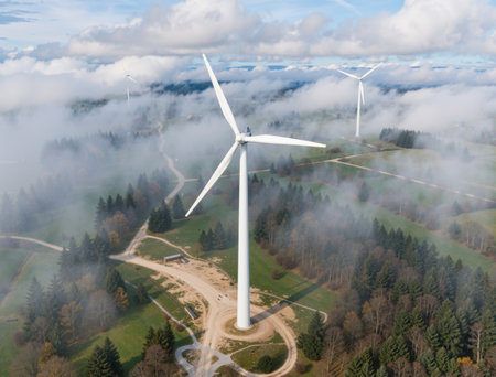 Aerial view of wind turbines in the middle of foggy forestの素材