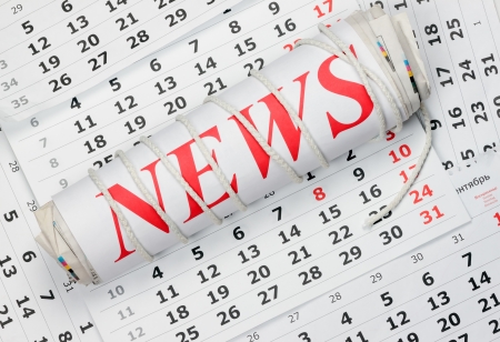 news Roll of newspapers tied with a rope lying on the calendarの写真素材