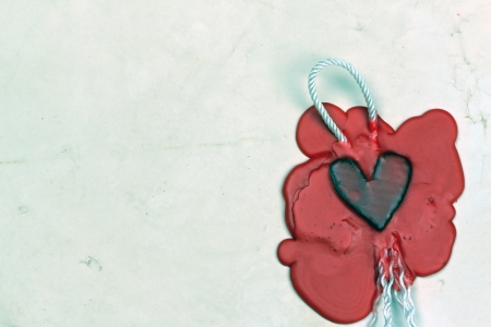 mark in the shape of a heart made  of red wax on the background of old paperの写真素材