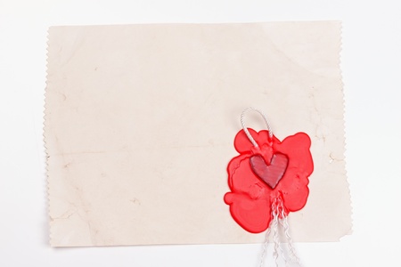 mark in the shape of a heart made ââof red wax on the background of old paperの写真素材