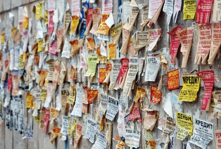 A wall in a city glued by teaf-off advertisement sheets. Moscow, Russia.のeditorial素材