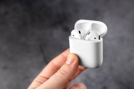guy holds air pods case in hand. Air Pods with Wireless Charging Case.