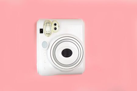Modern camera, photo pink wooden background. Top view, tender minimal flat lay style composition....