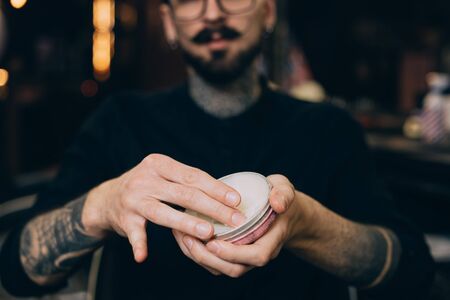 balm-wax. beard oils. barber shop beard care.jar with wax in the hands of a barbershop.の写真素材