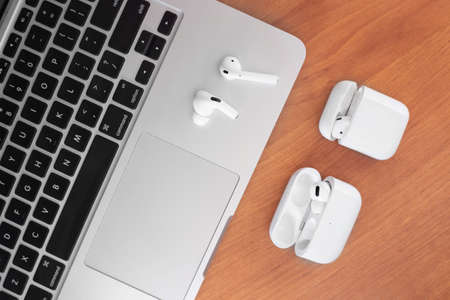 Air Pods Pro. macbook. with Wireless Charging Case. New Airpods pro on wooden background. Airpods....