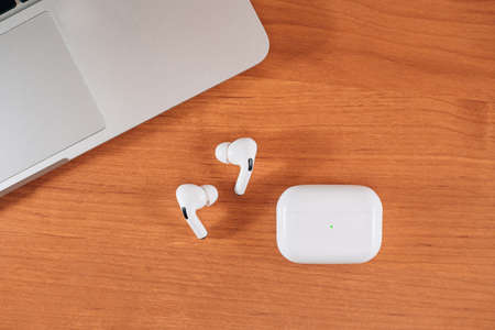 Air Pods Pro. macbook. with Wireless Charging Case. New Airpods pro on wooden background. Airpods....