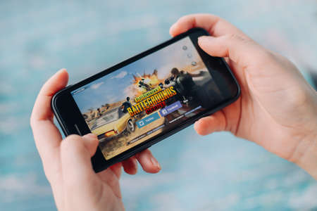 SAINT PETERSBURG, RUSSIA - MAY 27, 2020: Hands holding a smartphone with PUBG FPS gameのeditorial素材