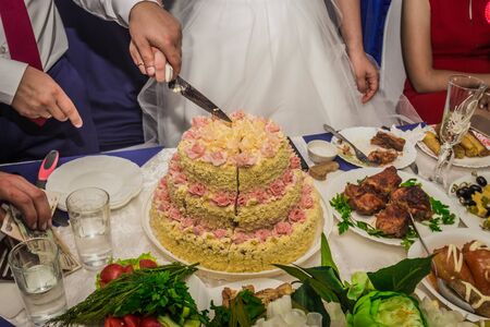 the bride and groom cut the wedding cake.の写真素材