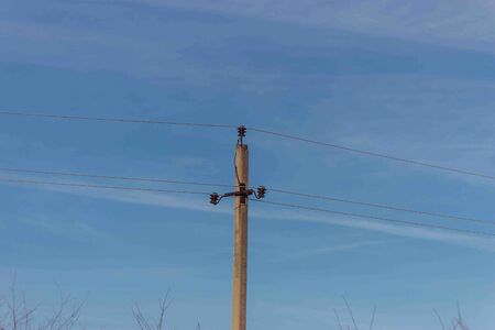 Pole and wires of power lines on the background of the autumn sky.の写真素材
