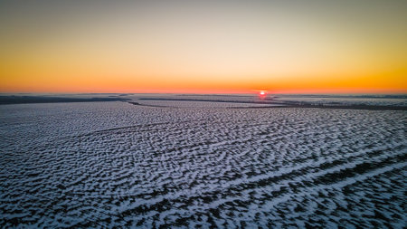 beautiful sunset in a winter frosty fieldの写真素材