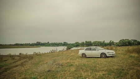 an old white car on the lake shore. High quality photoの写真素材