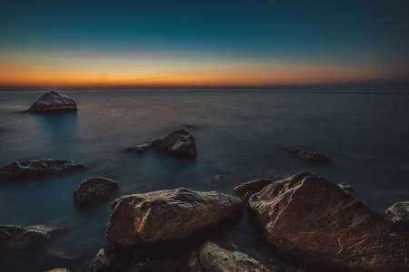 rocky coast of the mediterranean sea at dawn.の写真素材