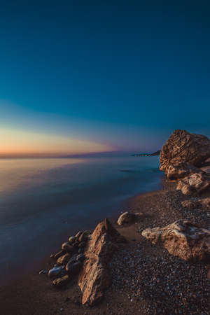 rocky coast of the mediterranean sea at dawn.の写真素材