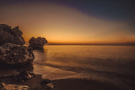 rocky coast of the mediterranean sea at dawn.の写真素材