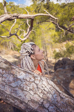 Rastafarian girl on a walk in a rocky forest.