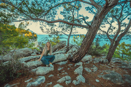 rasta girl with dreadlocks resting on the Mediterranean coast.