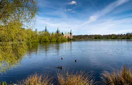 Morning sight of Frederiksborg Castle across the lake, settled in a town Hilerod, north-west of Copenhagen, Denmark. Ducks swimming in the lake.のeditorial素材