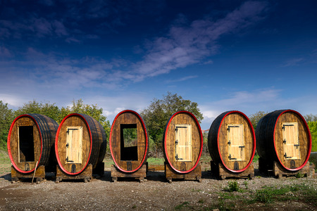 Six colorful huge wooden barrels with a doors