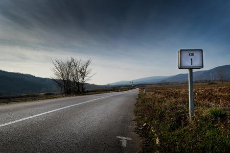 One kilometer sign on a country deserted roadの写真素材