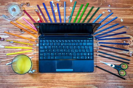 Graphic designer with laptop and color pencils on a wooden tableの写真素材
