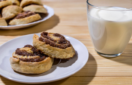 Sweet cinnamon rolls with milk on a wooden tableの写真素材