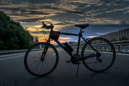 Silhouette of a Bicycle on the Highwayの写真素材