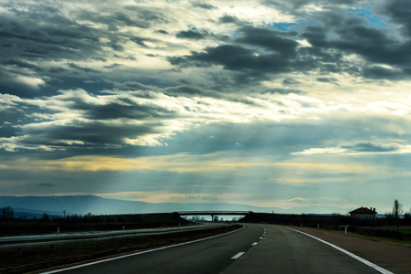 Two line wide highway on a cloudy winter day leading to the mountains through rural landscapeの写真素材