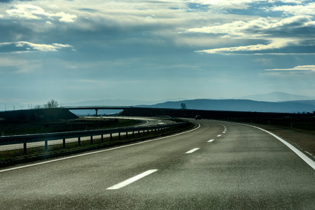 Two line wide highway on a cloudy winter day leading to the mountains through   rural landscapeの写真素材