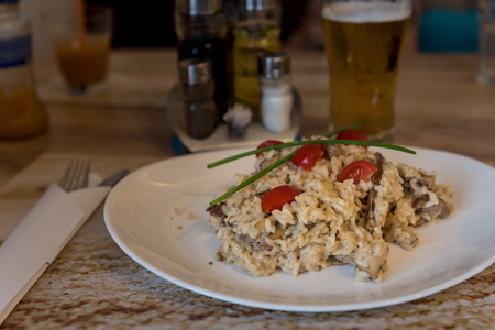 Risotto with Beef and Mushrooms on a Restaurant Wooden Table with utensils and spicesの写真素材