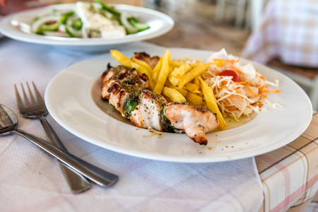 Greek meal pork souvlaki plate on a table in a Mediterranean Restaurantの写真素材