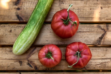 Organic Vegetables from a Small Garden on a Rustic Wooden Table - Tomatoes and Cucumberの写真素材