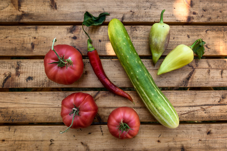 Organic Vegetables from a Small Garden on a Rustic Wooden Table - Tomatoes, Cucumber, Paprika, Bell Pepper, Chili Pepperの写真素材