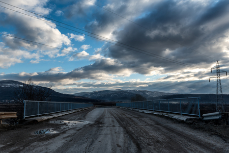 Dirt Country Road Crossing under a dramatic cloudy skyの写真素材