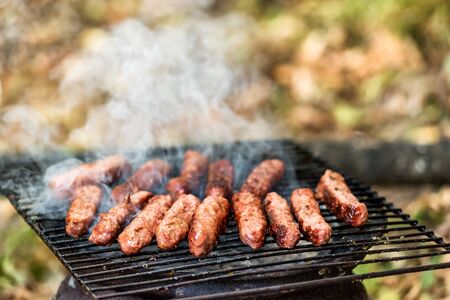 Balkan cuisine Pork Cevapi, grilled minced meat, on the improvised grill