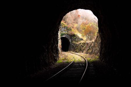 Old abandoned railway passing through short tunnels in picturesque rural scenery